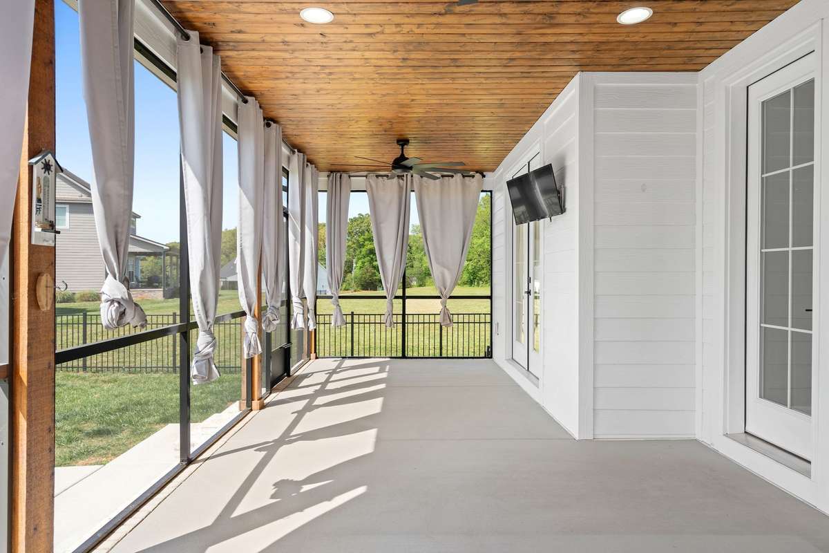 Beautiful outdoor living space with fireplace and mounted TV—ideal for relaxing or entertaining.