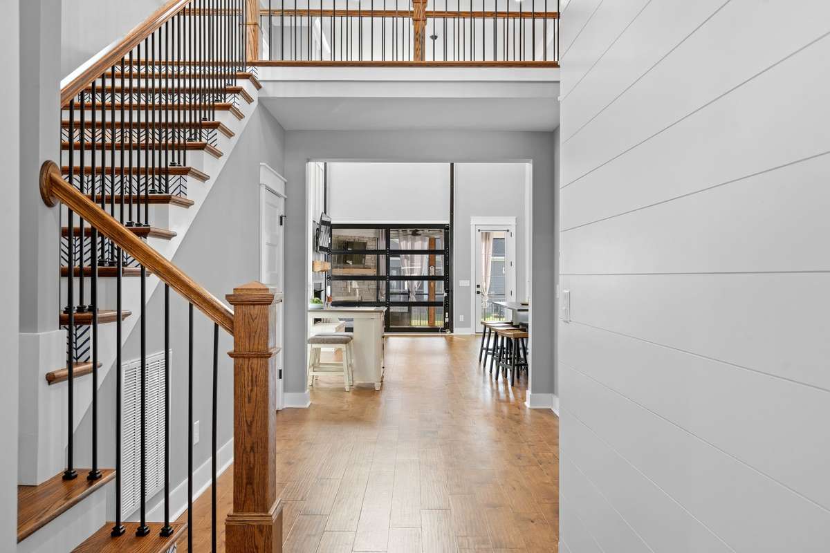 Grand entry foyer with soaring ceilings, hardwood floors, and an open view into the main living spaces.
