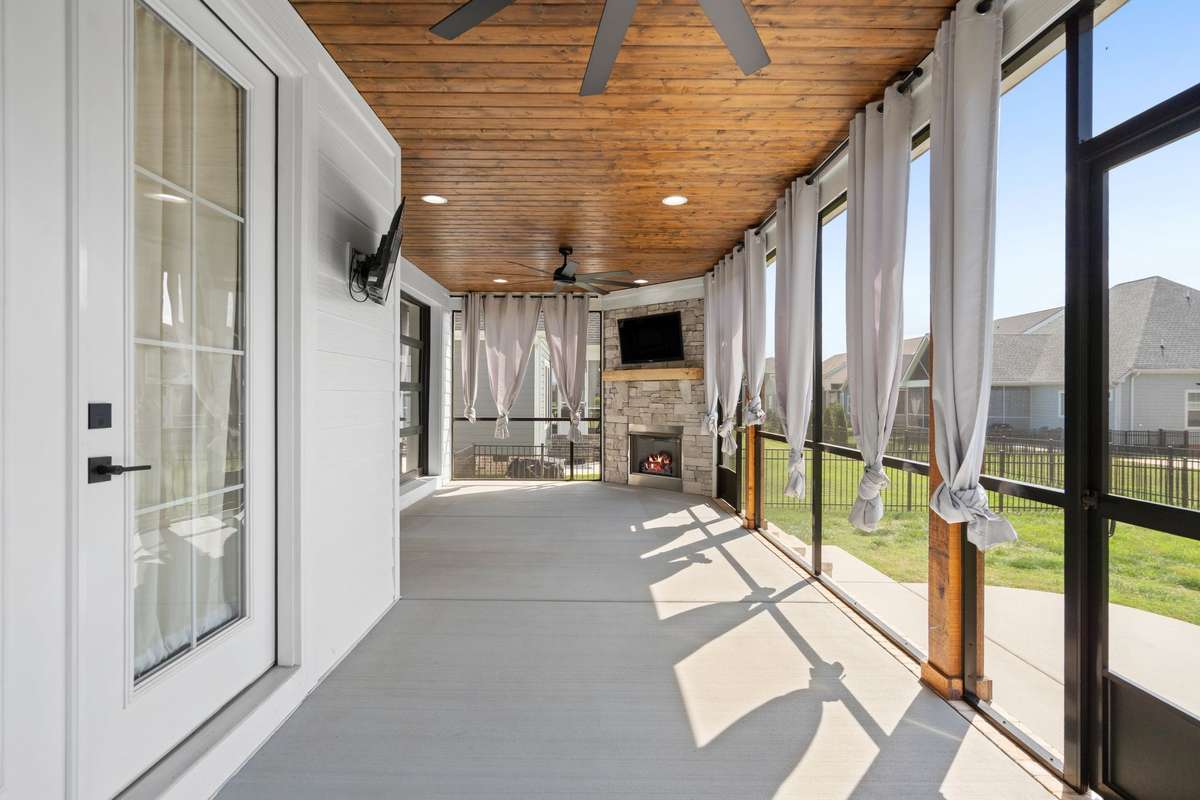 Large screened porch with wood ceiling, ceiling fan, and gas fireplace—perfect for year-round enjoyment.