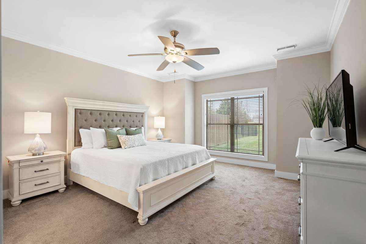 Comfortable primary bedroom with large window and soft natural light.