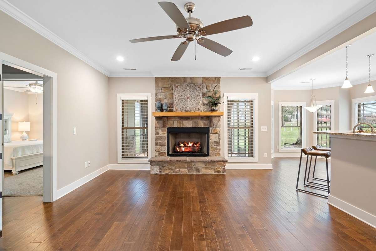 Living room with cozy gas fireplace and seamless flow to kitchen and dining spaces.