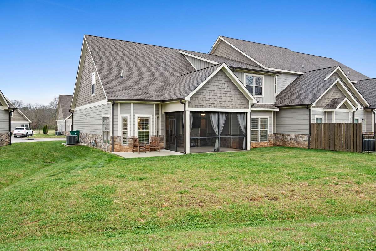 Rear exterior view highlighting the large lawn and covered patio space.