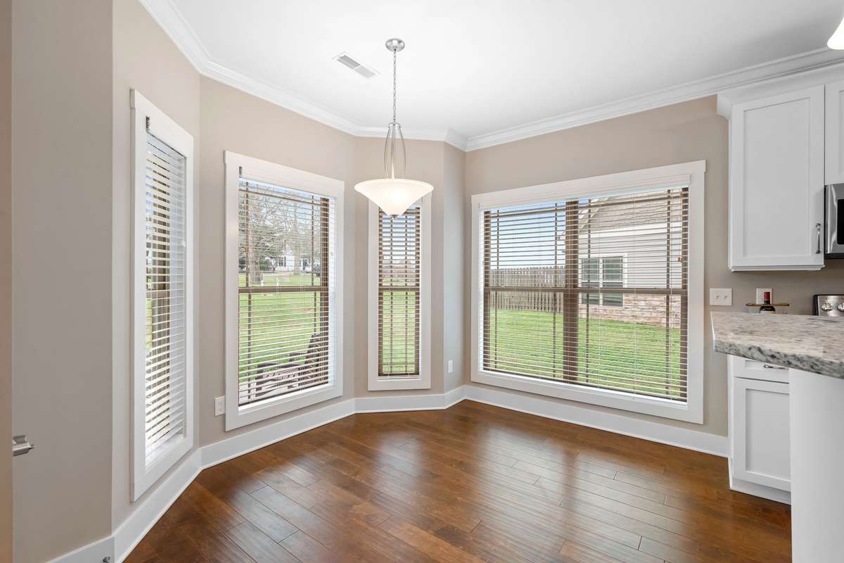 Bright kitchen and breakfast area surrounded by windows overlooking the yard.
