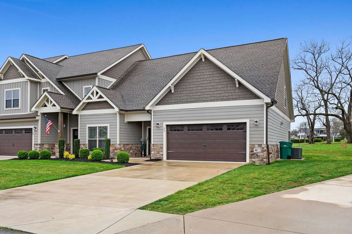 Attractive front elevation featuring stone accents, attached garage, and low-maintenance landscaping.
