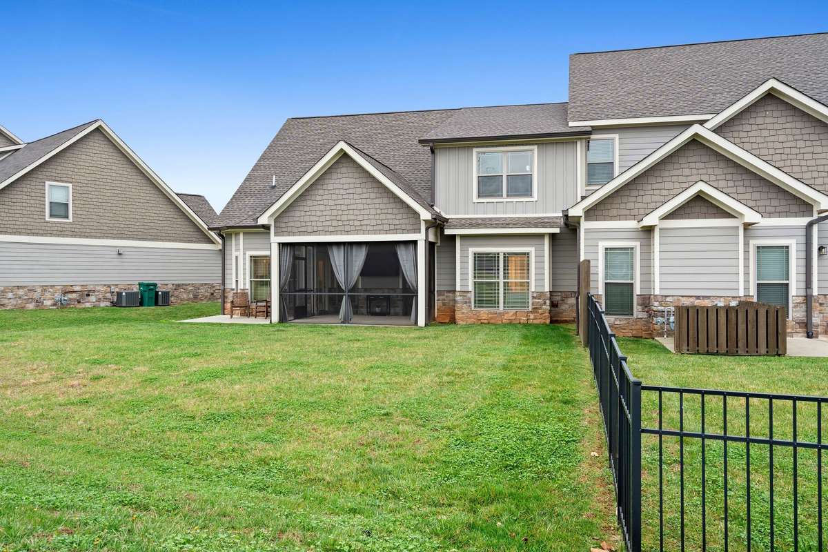 Backyard perspective showing the townhome’s screened porch and outdoor seating area.