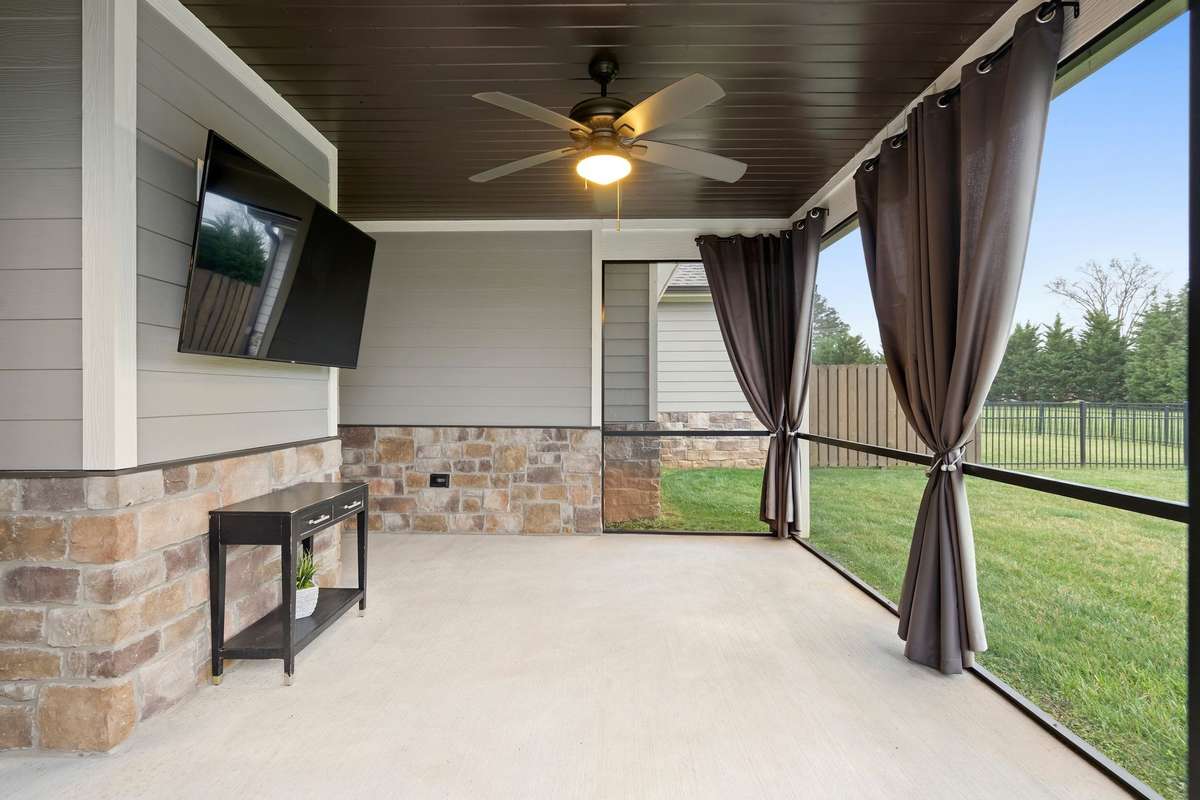Spacious screened porch overlooking the backyard and open green space.