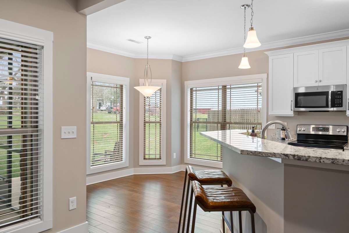 Kitchen with granite countertops, white cabinetry, and breakfast bar for casual dining.