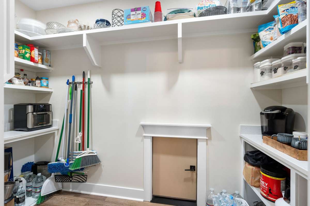 Spacious walk-in pantry with custom shelving—ideal for organized storage of appliances and essentials.