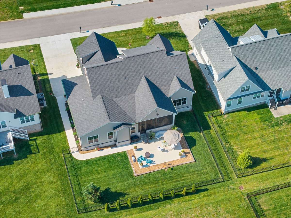 Overhead view of the home showcasing the fenced backyard, outdoor living space, and screened porch.