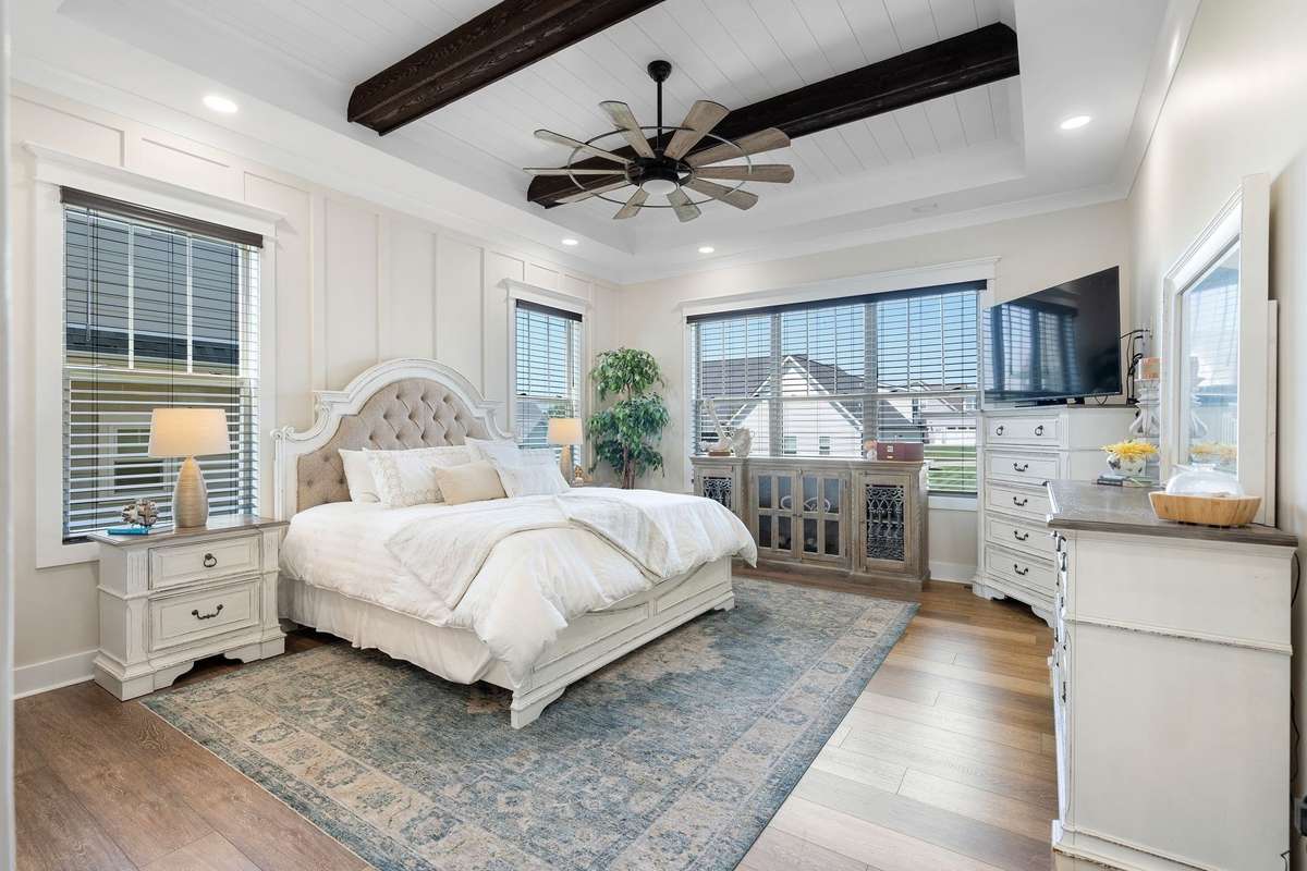 Spacious primary suite with tray ceiling, abundant windows, and a light, airy feel.