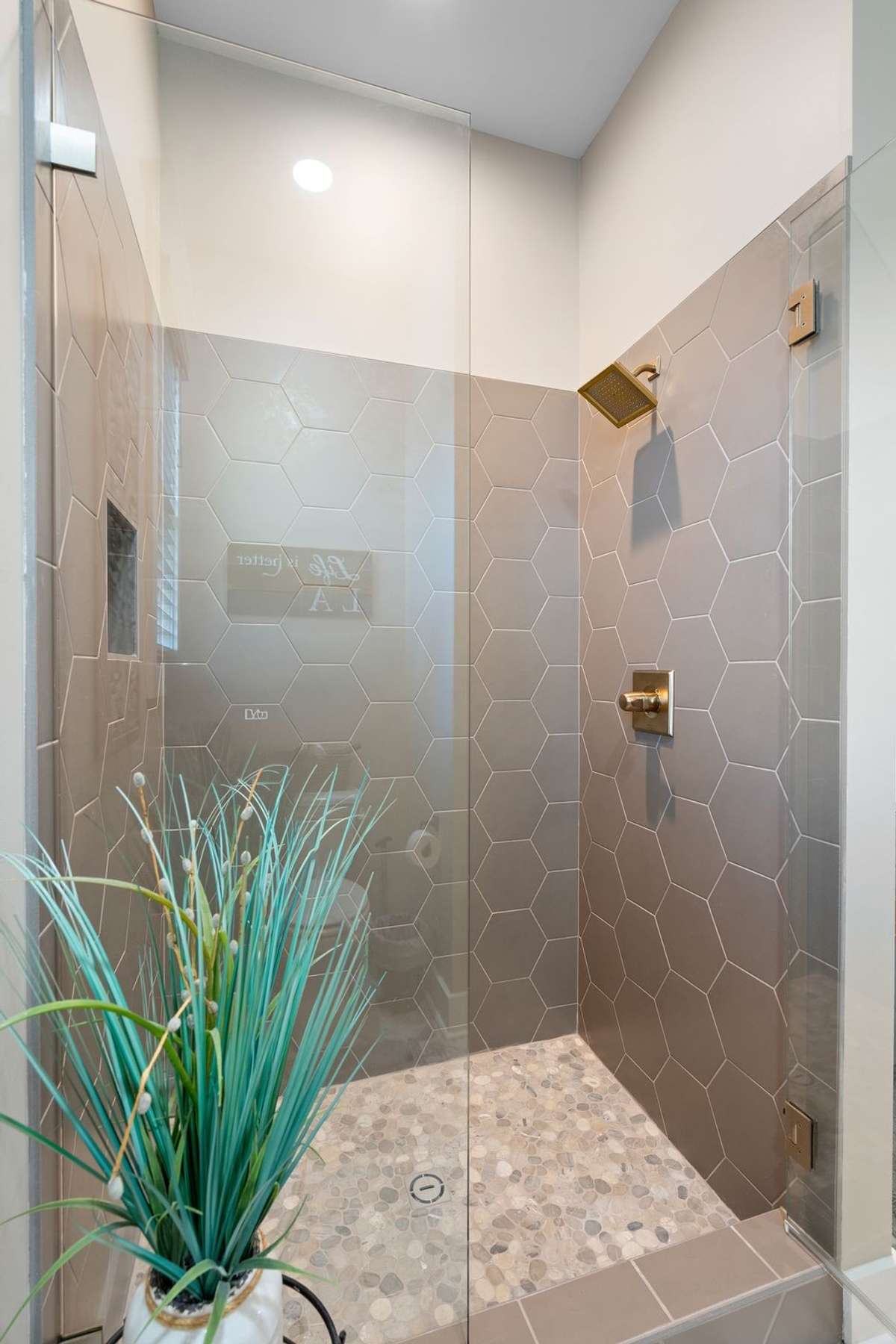 Beautifully tiled walk-in shower featuring glass enclosure and upscale finishes.