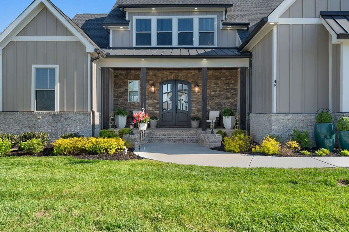 Charming covered entry with stone detail and double doors—creating a warm and inviting first impression.