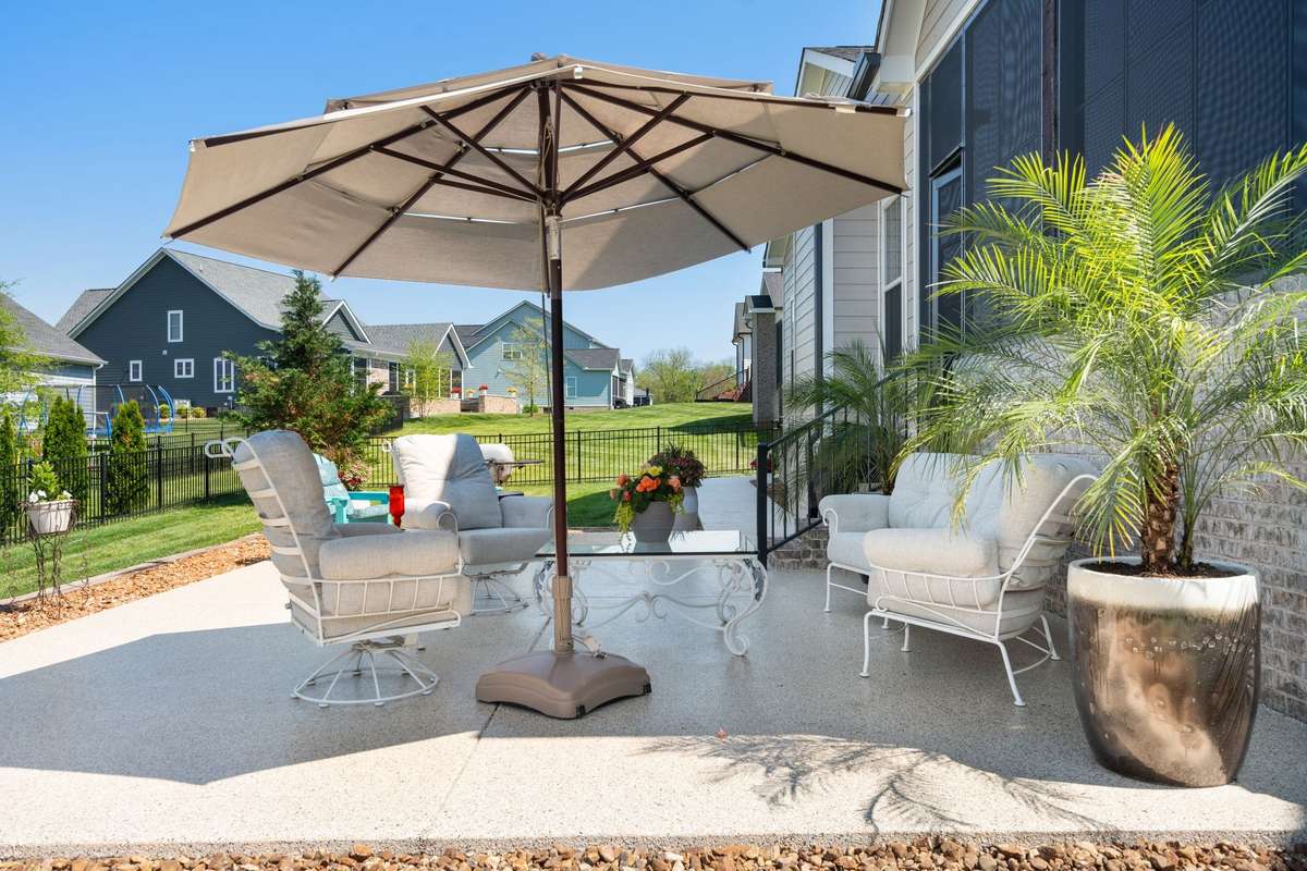 Charming outdoor seating area with umbrella and garden accents—ideal for morning coffee or evening unwindin
