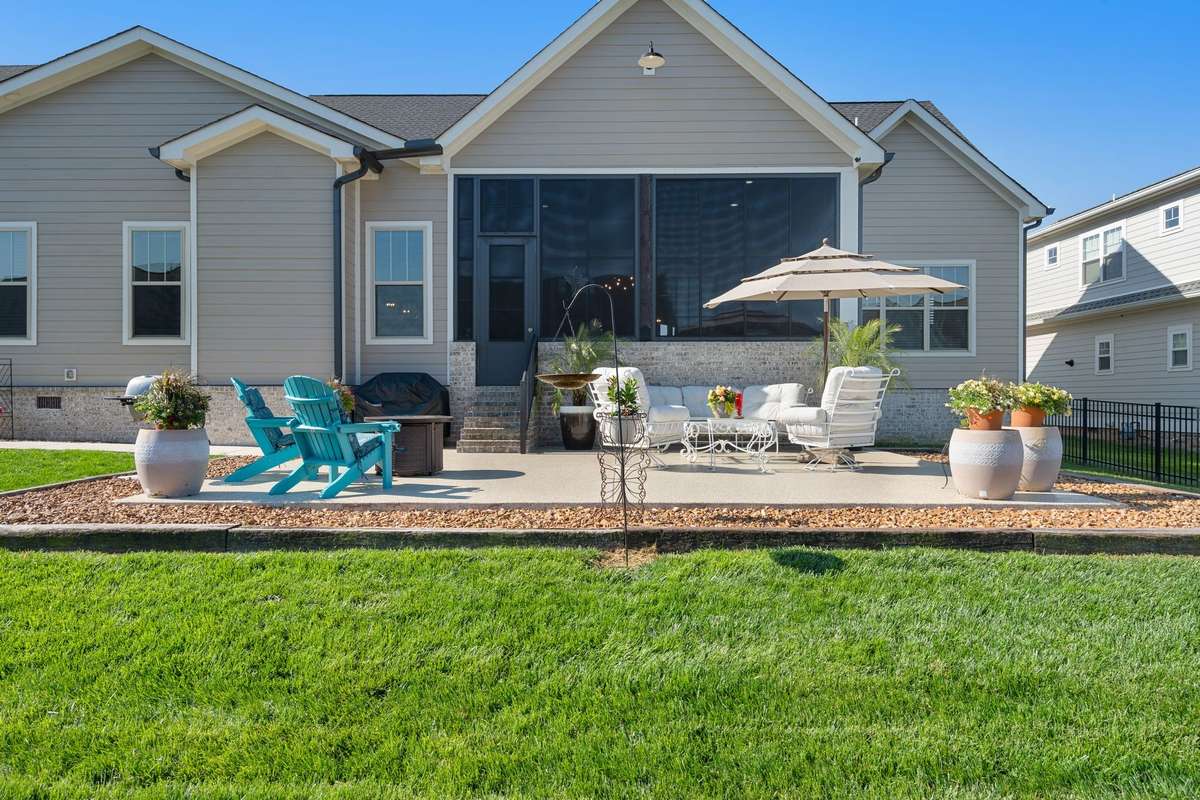 Expansive patio perfect for gatherings, featuring ample seating space and easy access to the screened porch.