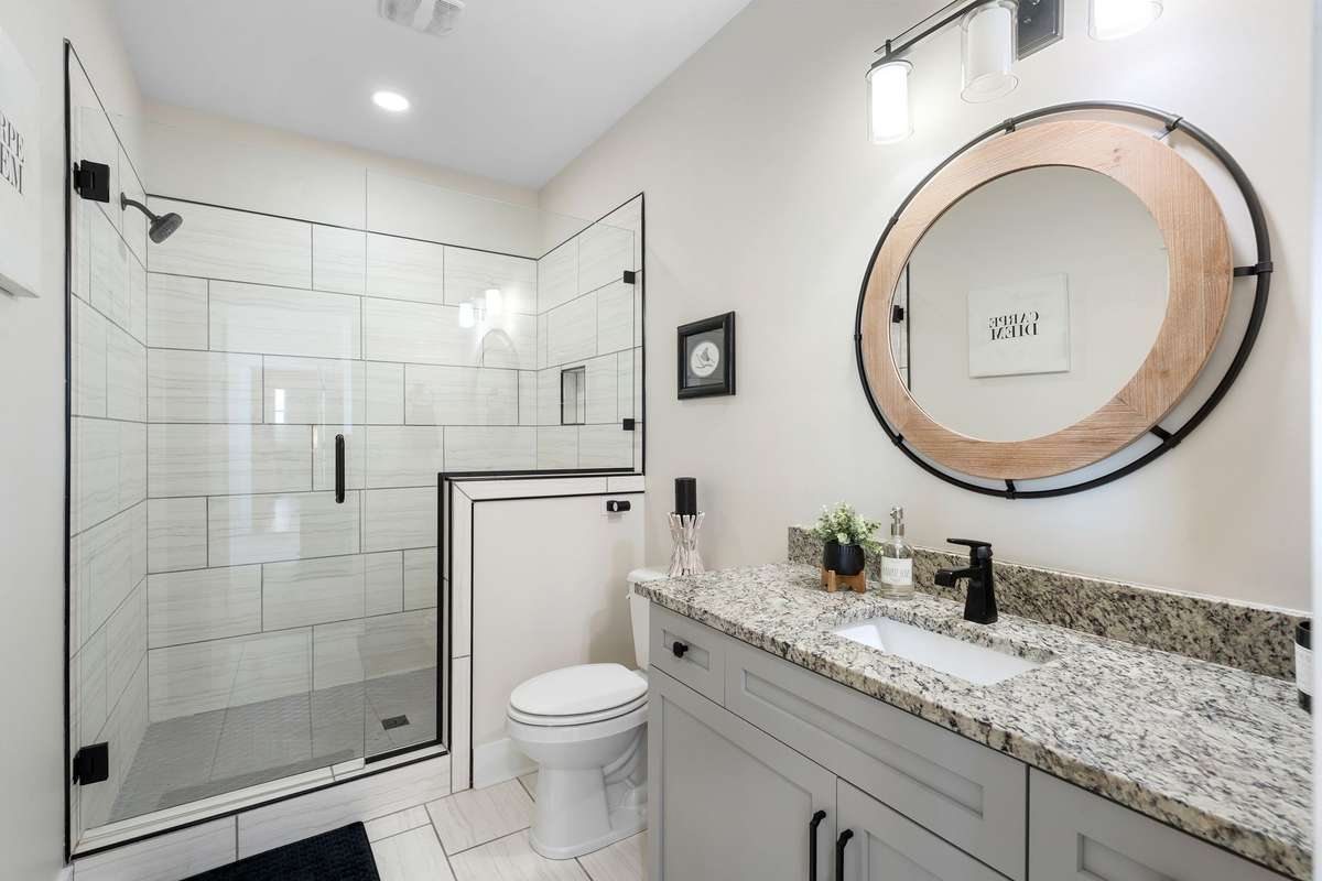 Beautifully finished bathroom with granite countertops and tiled walk-in shower.