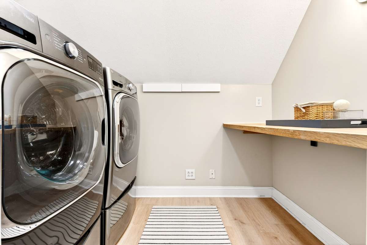 Upstairs Laundry Room - Conveniently relocated to the 2nd floor with a new washer (includes a mini-load unit) and dryer, a large folding table, and additional lighting.