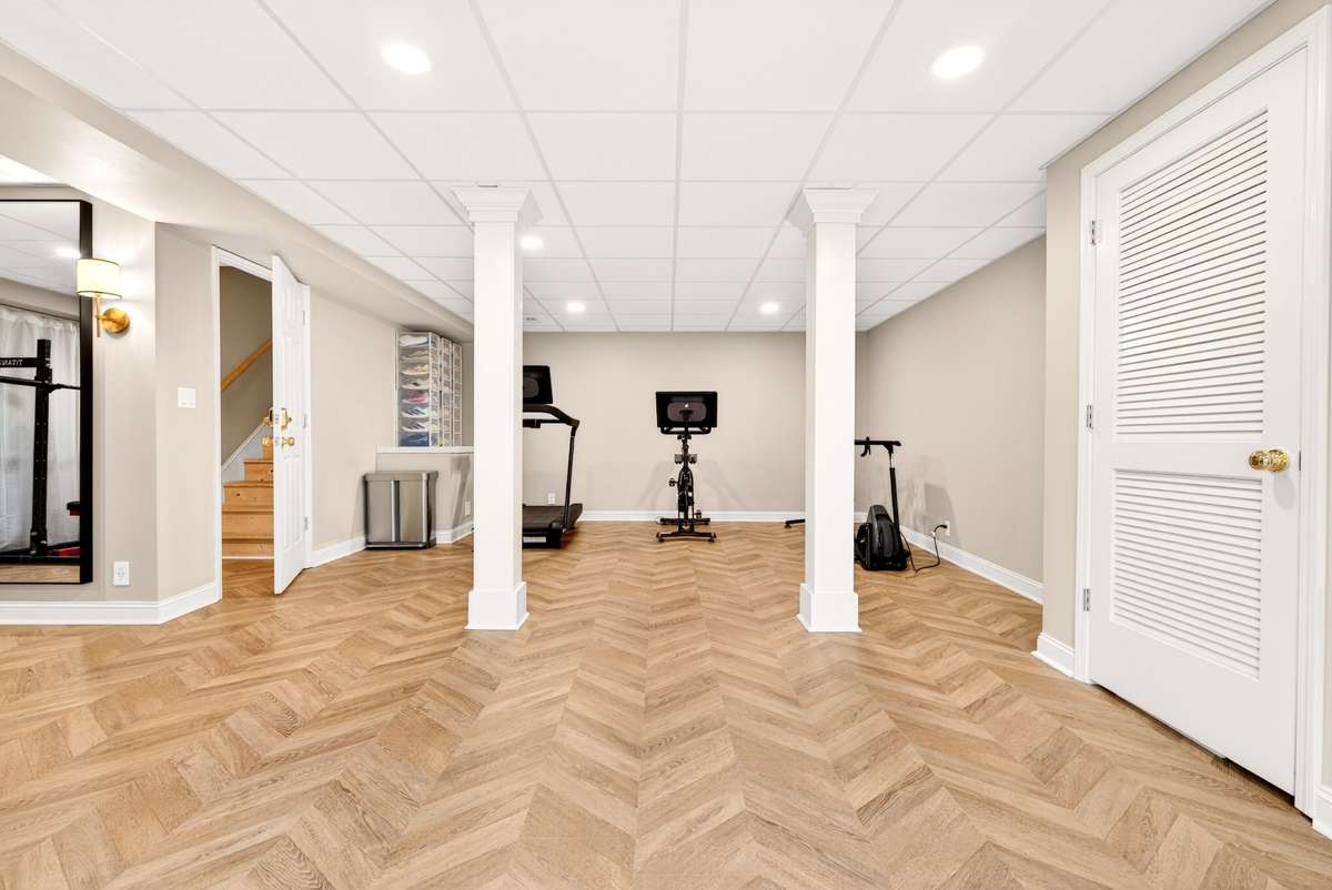 Professionally excavated and fully finished basement that includes:  Gym with French doors, engineered herringbone flooring, LED & sconce lighting, secured keypad entry, bonus playroom, utility closet, storm shelter under stairs