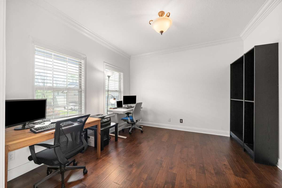 Office with french doors and wood floors across from dining room