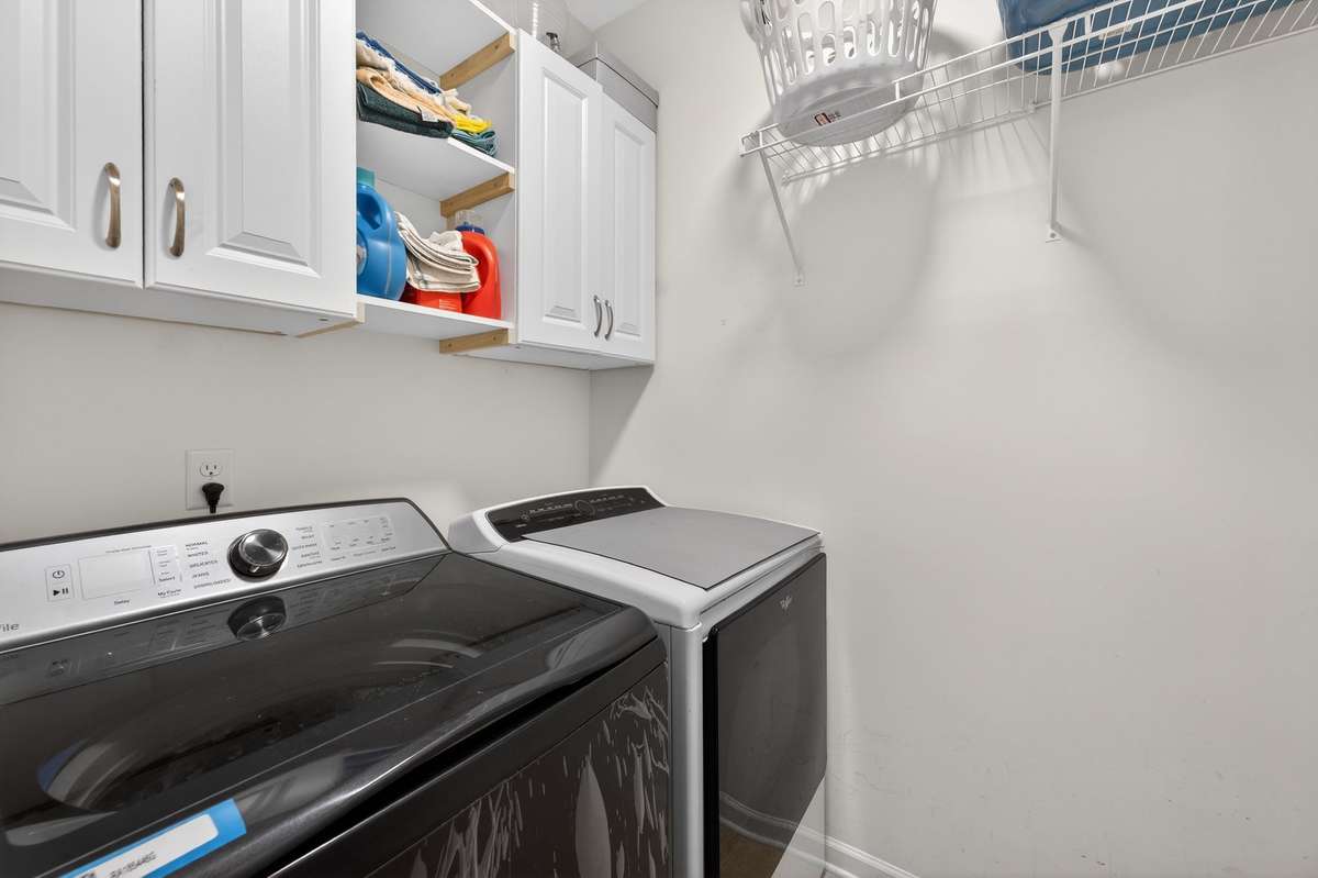 Laundry room with caninets and shelving for hanging clothes