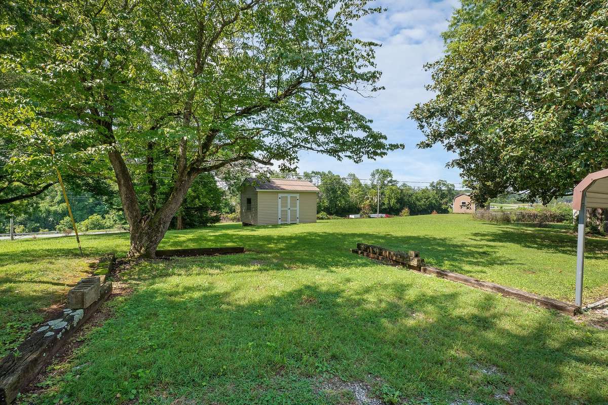 The backyard has plenty of room for children to play and has a storage building that will remain with the home.