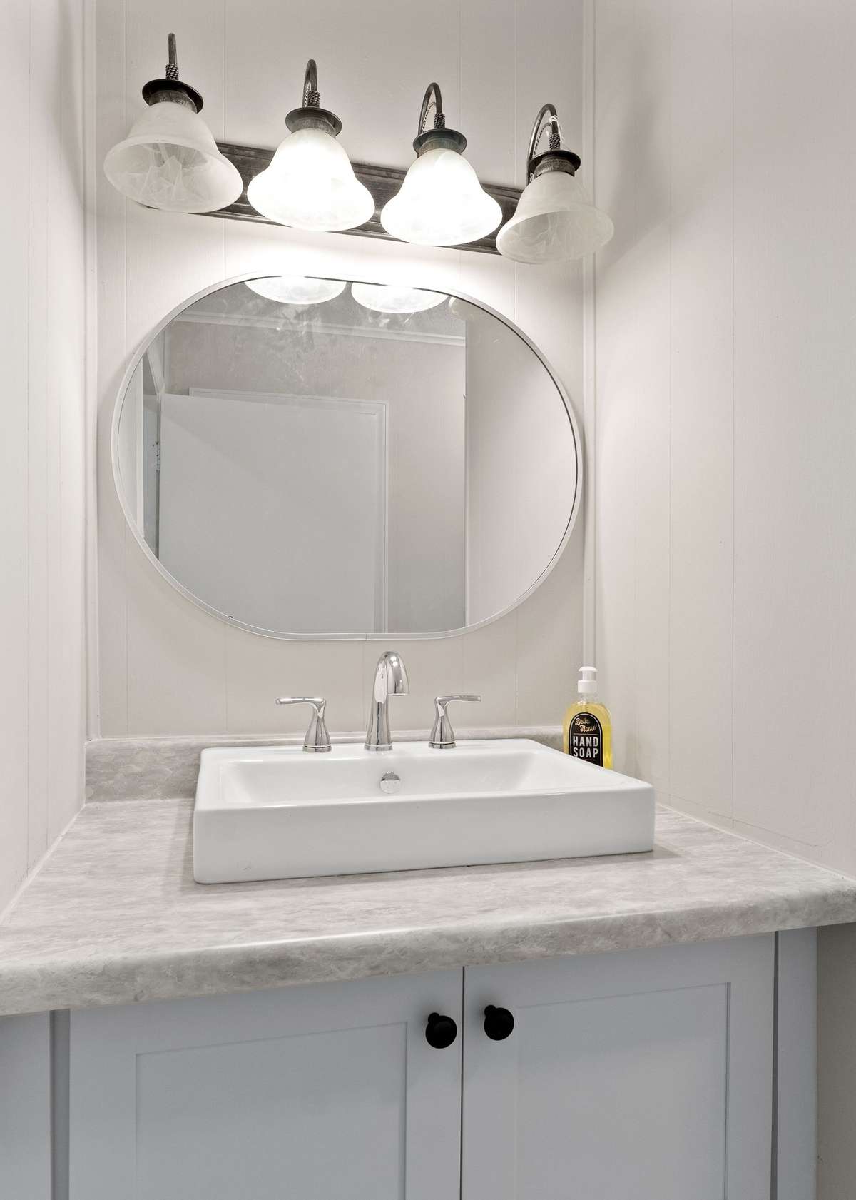 The bathroom has new sink, faucet, lighting, paint and flooring.