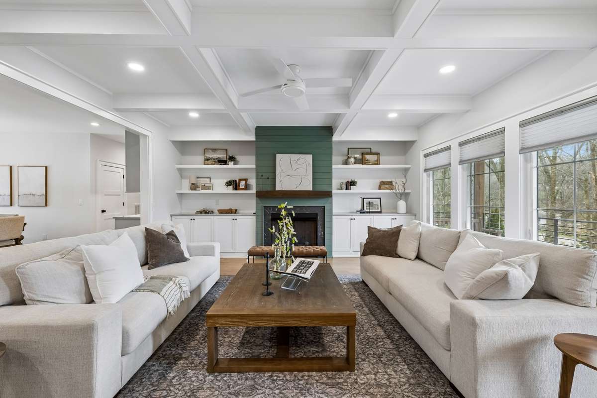 Living area features high ceilings, functional gas fireplace and custom built-in shelving and cabinetry.