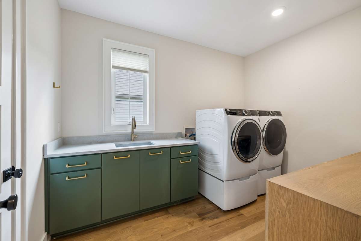 First floor oversized laundry room situated off the primary walk-in closet includes bolted down safe for storage of valuables.