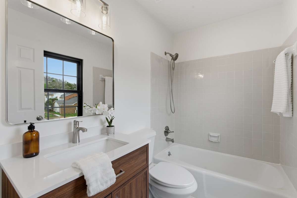 Primary bath with new vanity, mirror, lighting, and more.