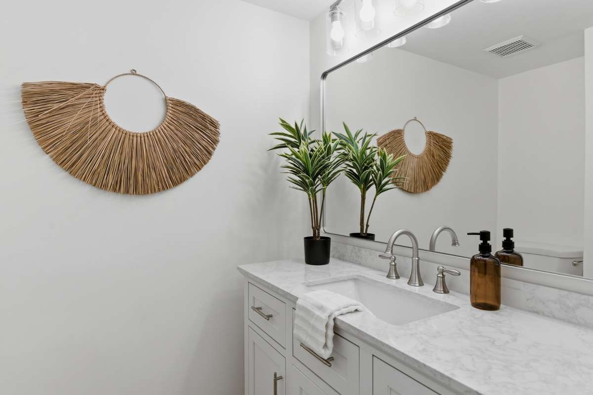 Half bath on first floor is tucked discreetly in hallway. New vanity, plumbing and lighting fixtures.