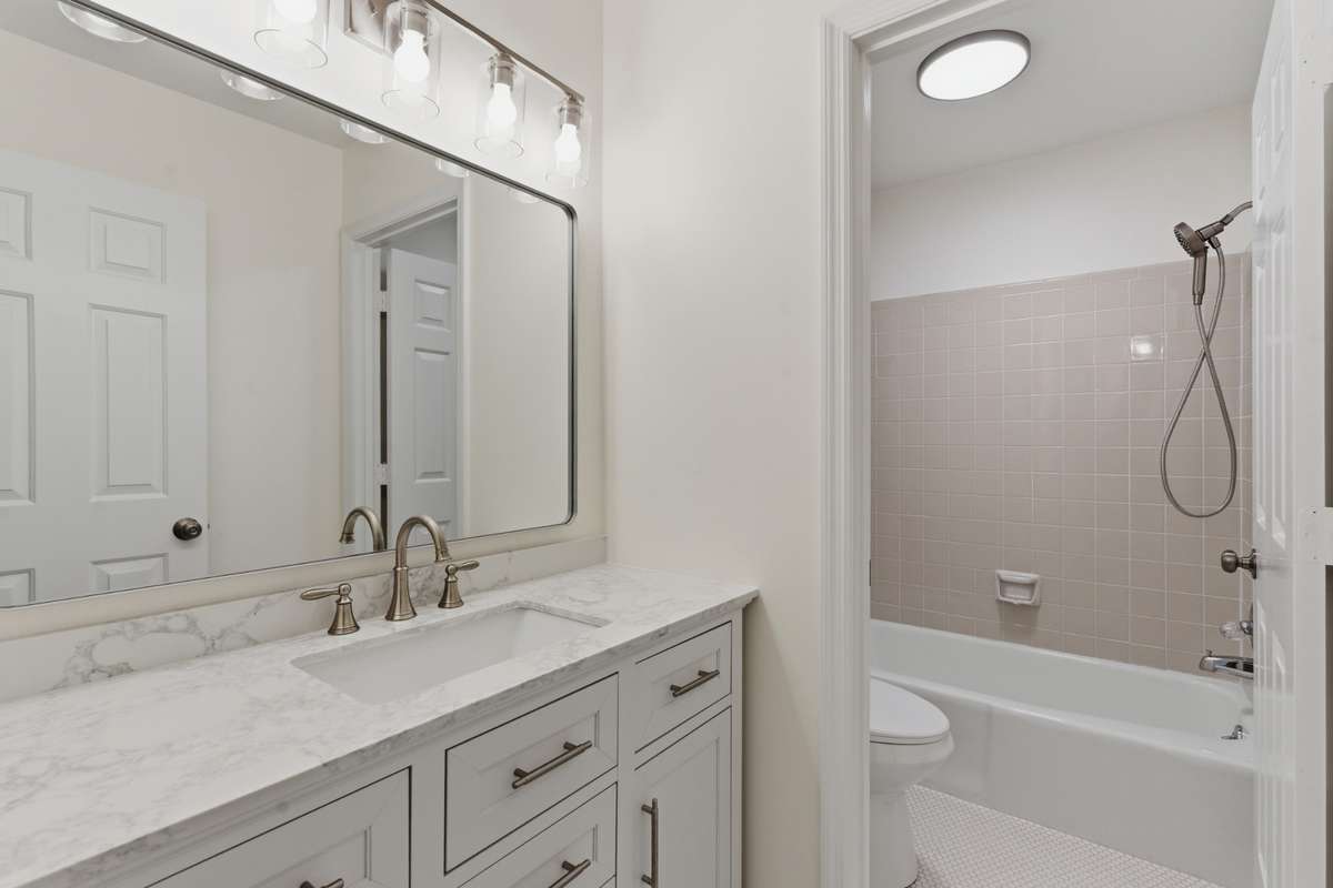 Secondary full bath upstairs has new vanity with quartz tops, lighting, tile floor, mirror, plumbing and more.