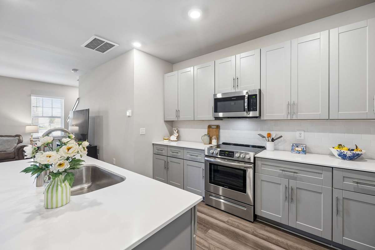Beautiful kitchen featuring stainless appliances, tile backsplash and quartz countertops
