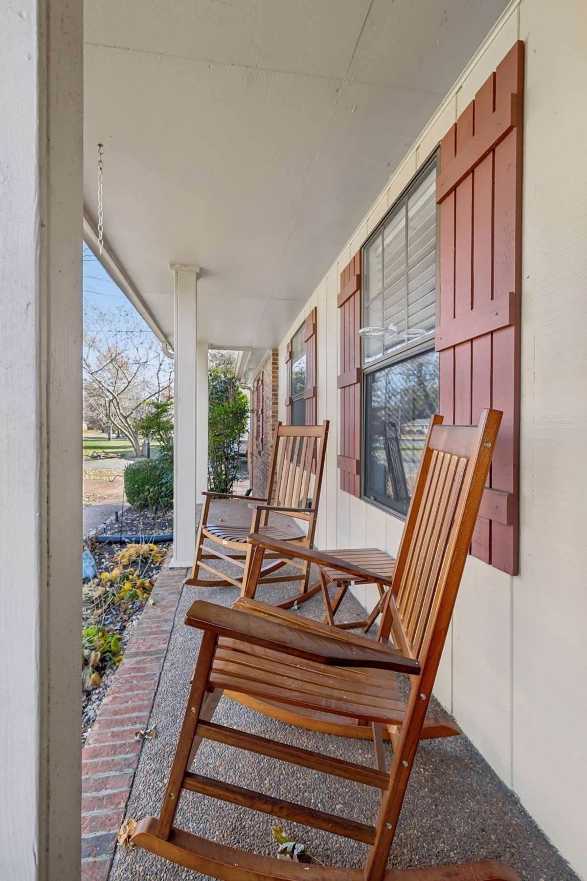 Inviting entryway framed by landscaping and brick accents. A warm welcome home.