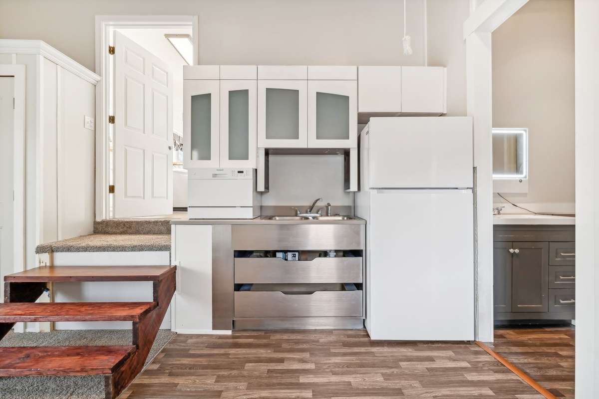 Convenient kitchenette with cabinets, counter, and fridge for independent living.