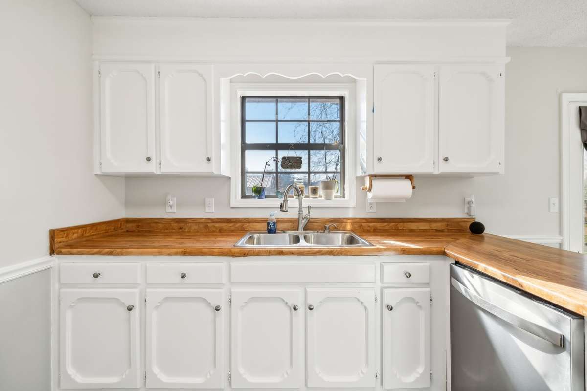 Spacious kitchen with double sink overlooking the backyard, perfect for multitasking.