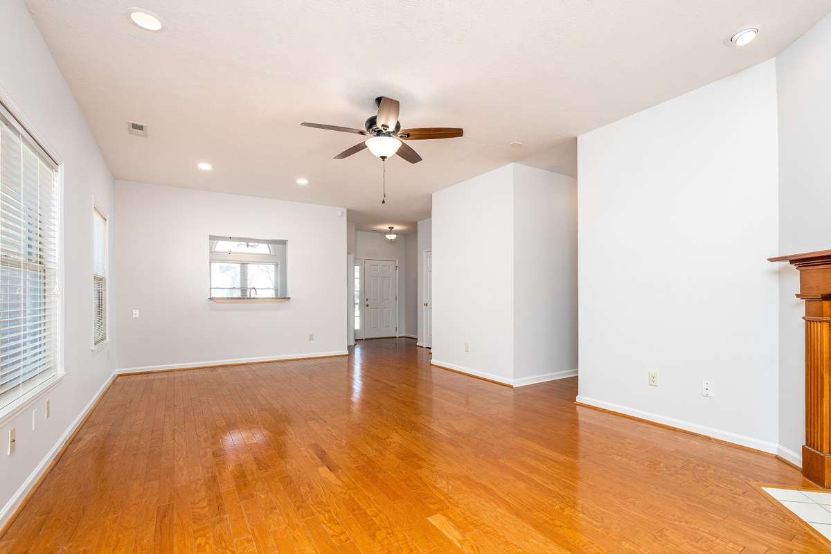 Family Room looking toward the Kitchen and Front Door. Hardwood flooring and plenty of light  with multiple windows
