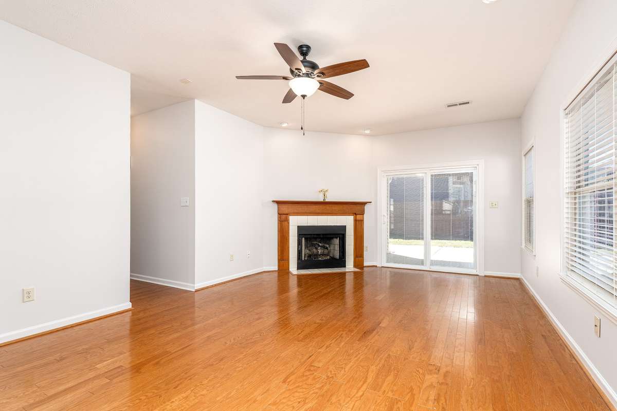 Spacious Family Room with Hardwood floors and  gas log in Fireplace. Sliding Doors lead to the private fenced in back yard.