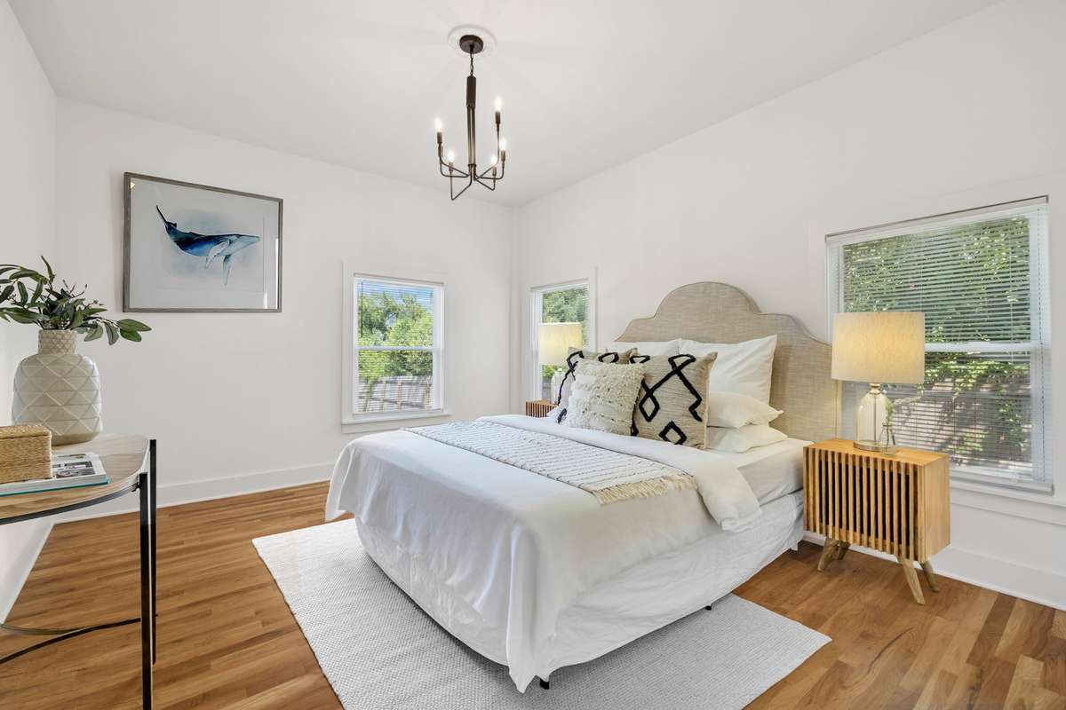 This photo features the primary suite, which is located on the main floor.  The room has been virtually staged.