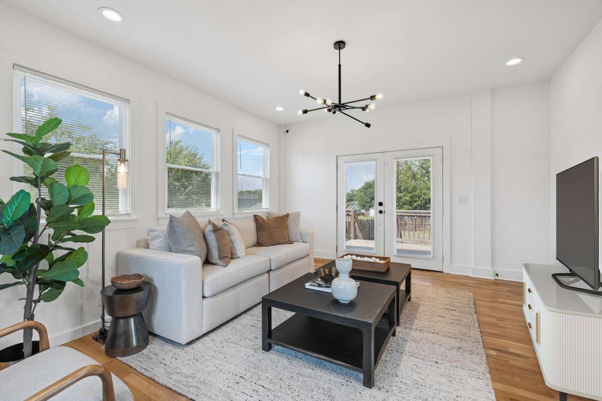 This photo features the same space that is open to the kitchen.  However, it's virtually staged as a living room/den.  The French doors lead to the back deck.