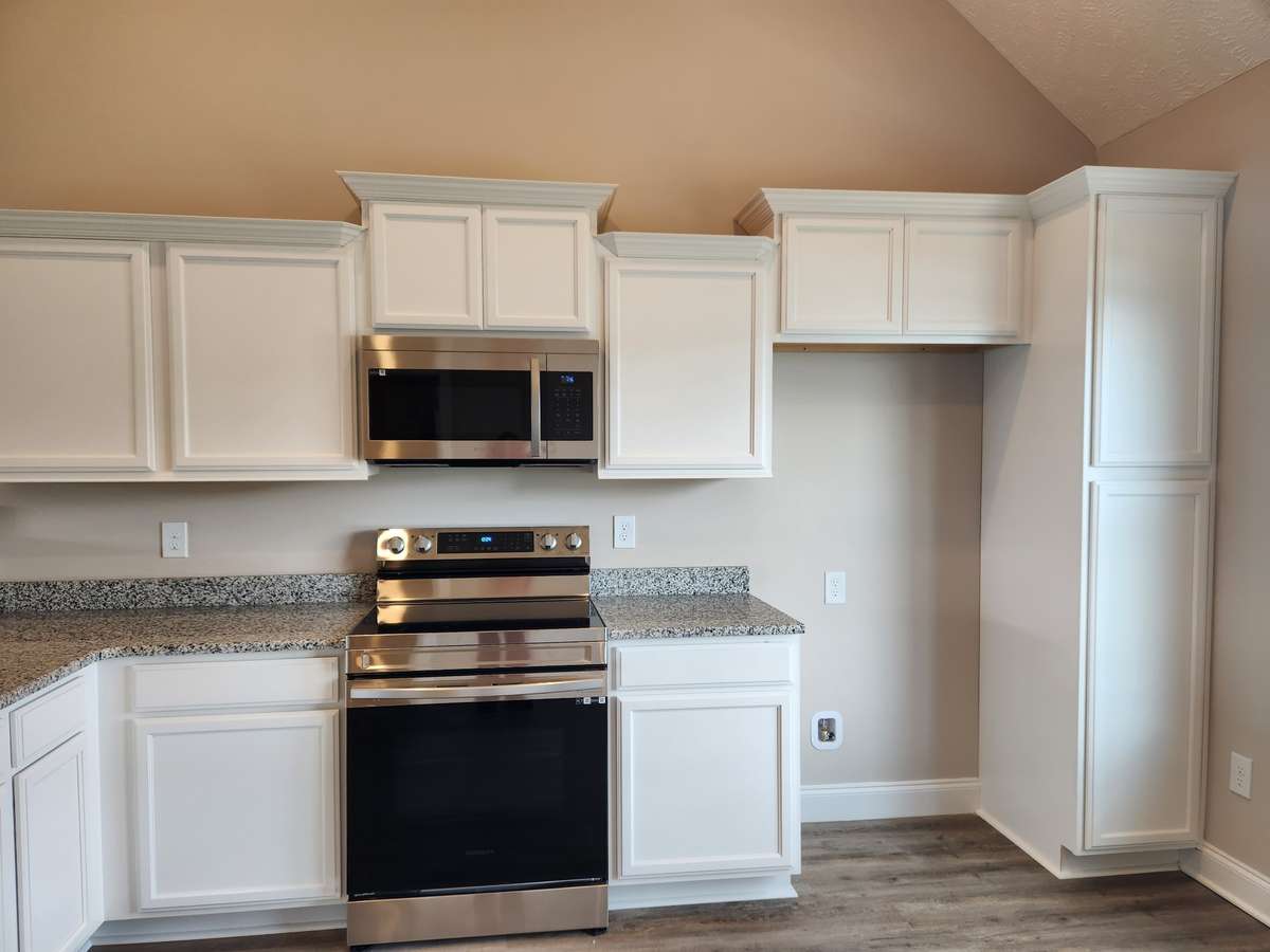 Upgraded Custom Dark Cabinets are stacked at the Top, have nice Crown Molding and Granite Counter Tops.   Picture of similar house.