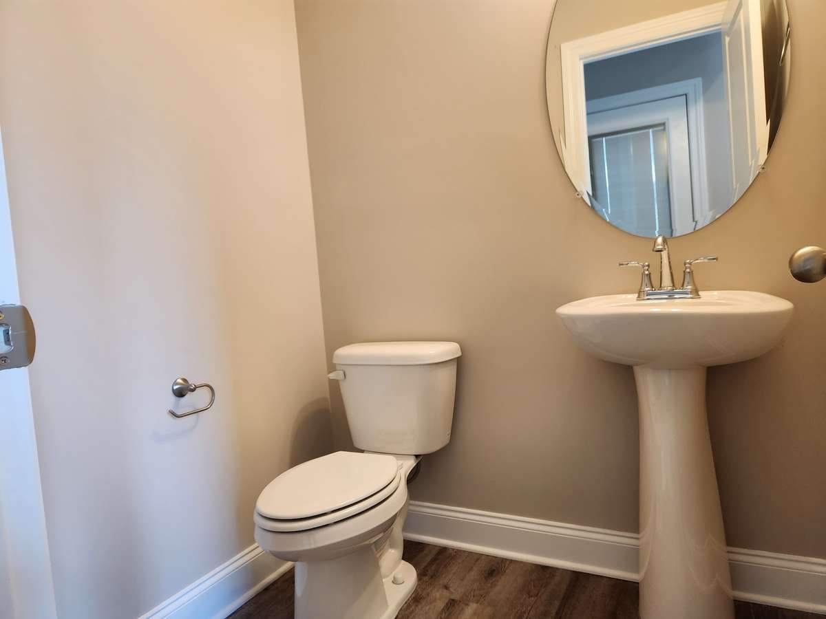 Half Bath on Main Level has Pedestal Sink and LV Plank Flooring. 
Picture of Similar House.