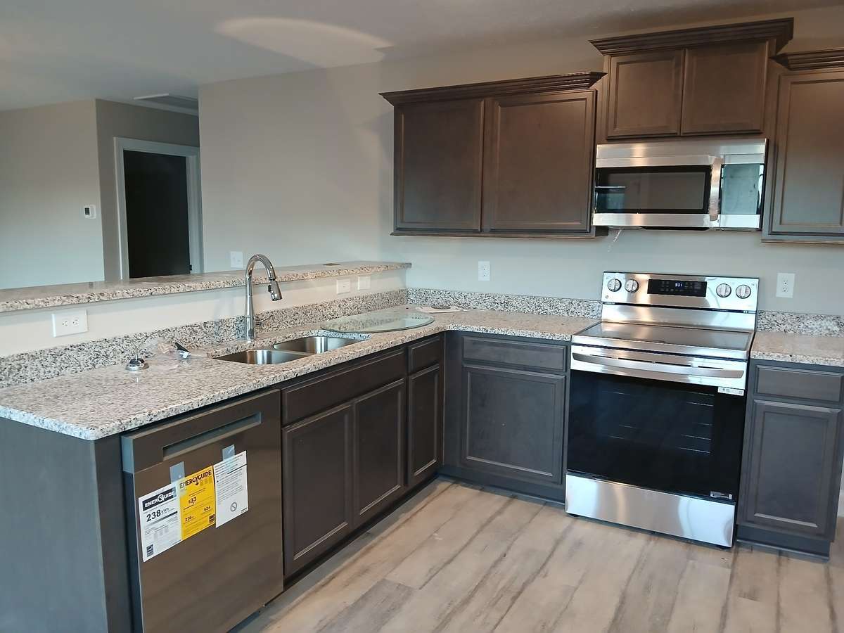 Kitchen Features Custom Cabinets & Stainless Stove, Microwave & Dishwasher.