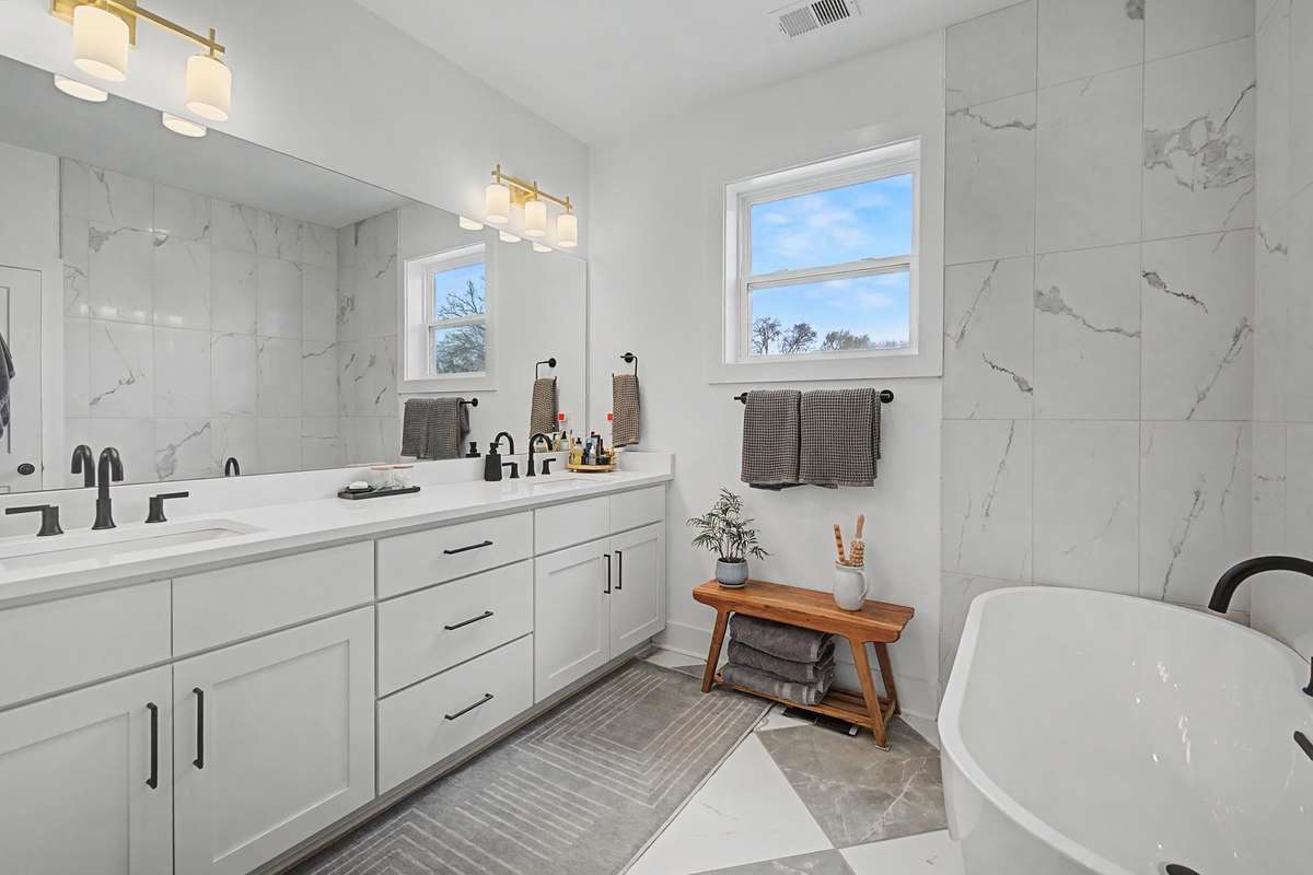 Primary Bathroom with Plenty of Storage and Marble Finishes Surrounding the Soaking Tub