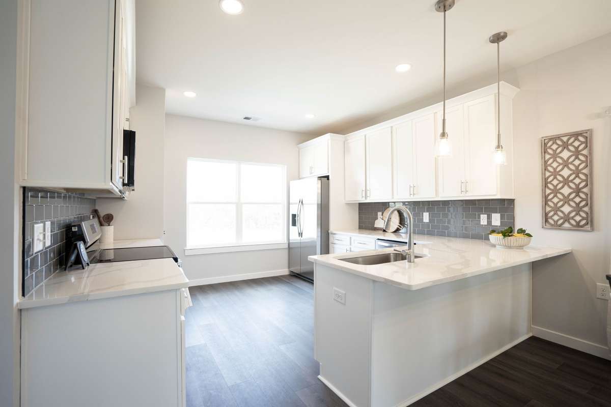 Large kitchen with tile backsplash, 3cm quartz countertops, large peninsula for added eating area, and prep space!