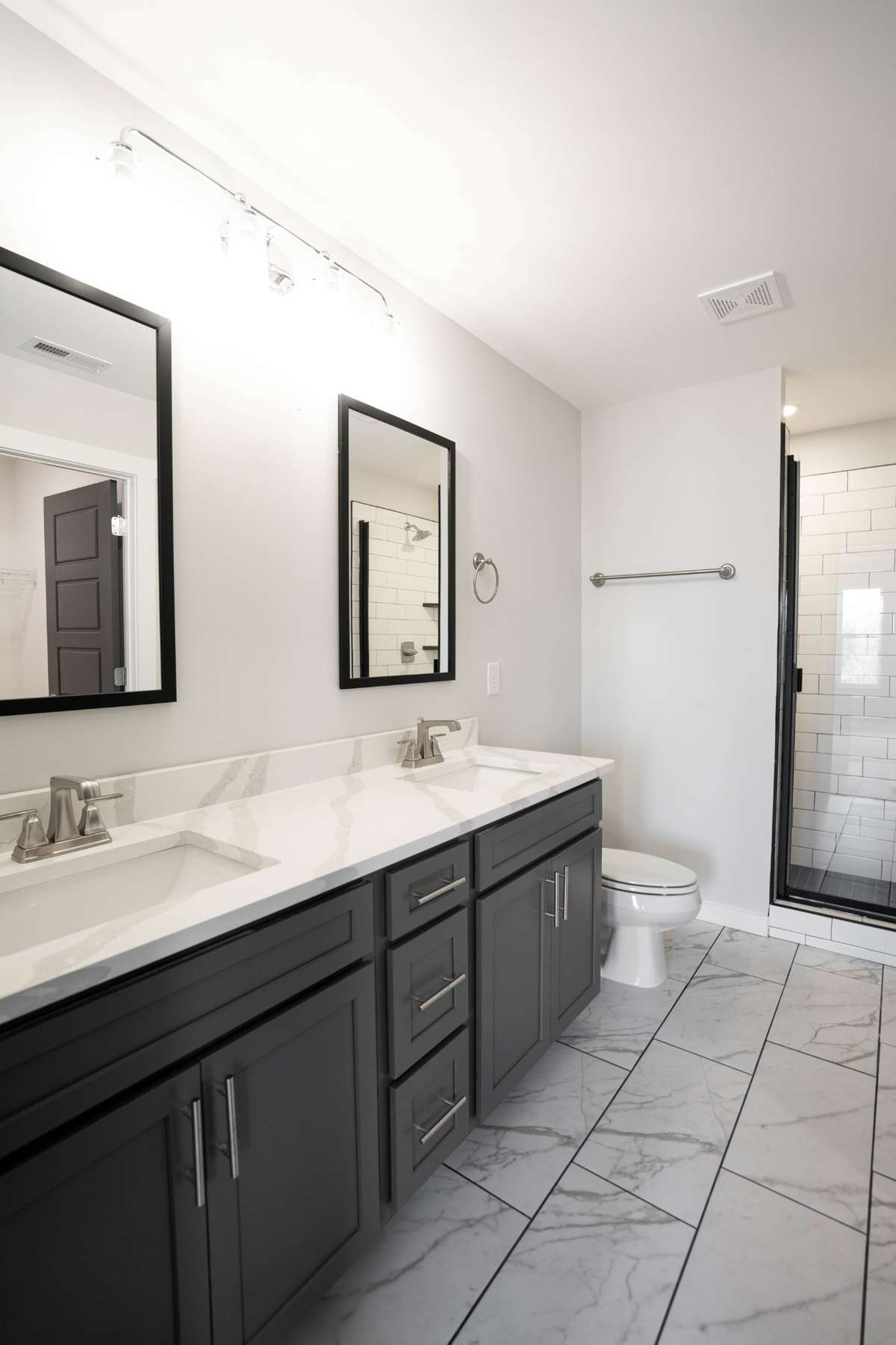 Double vanities, gorgeous tile floor, and tiled shower with built in shelves and bench.