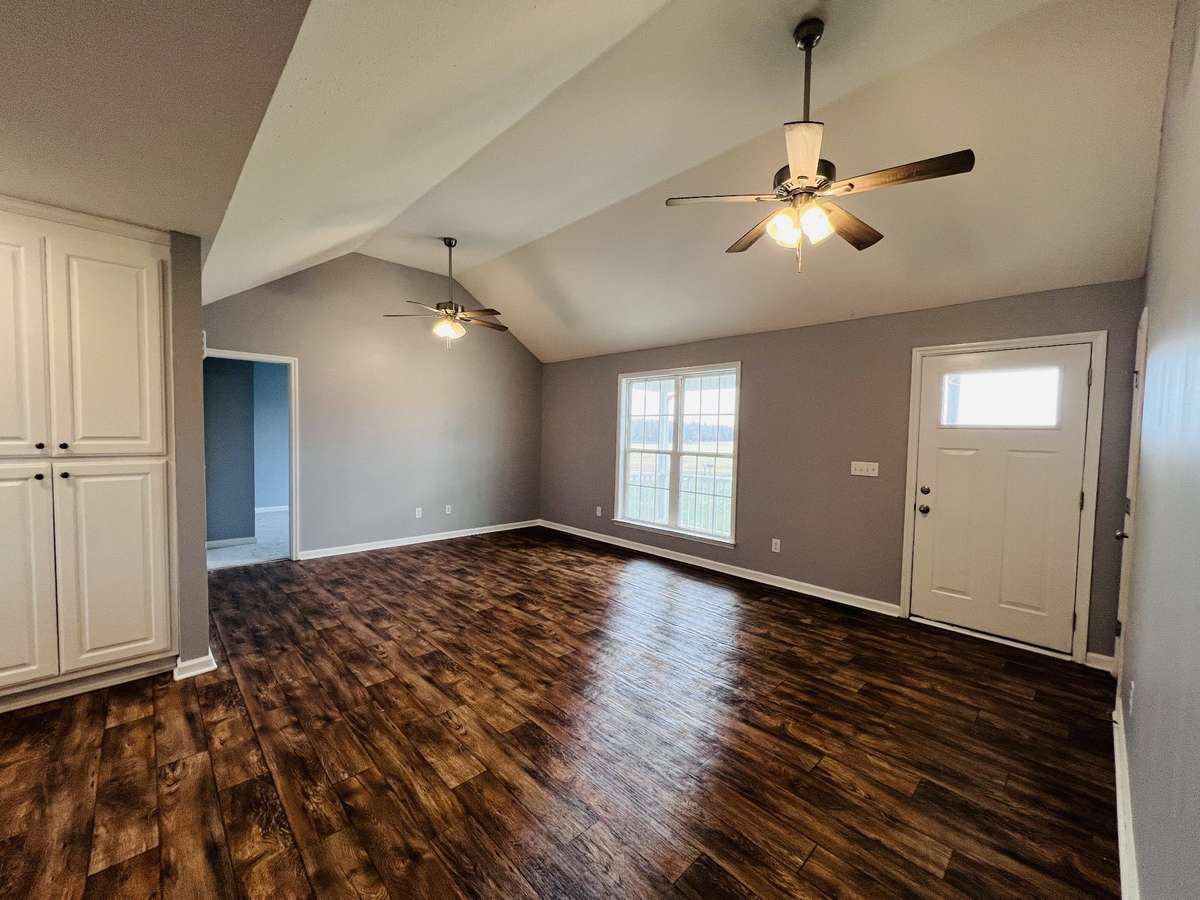 Living area with two ceiling fans and a vaulted ceiling