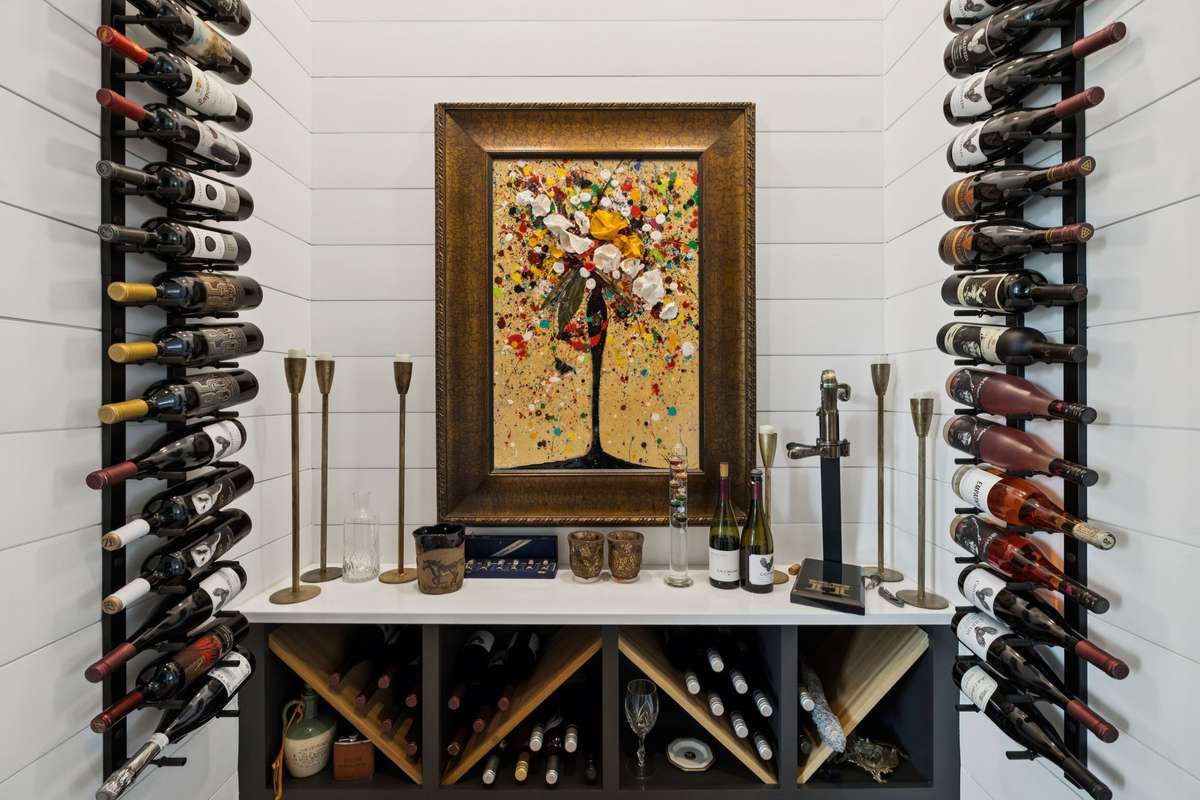 Glass-enclosed wine display with custom racking creates a striking focal point. Perfect for collectors and entertainers alike, this dedicated space keeps your favorite bottles organized and ready to enjoy.