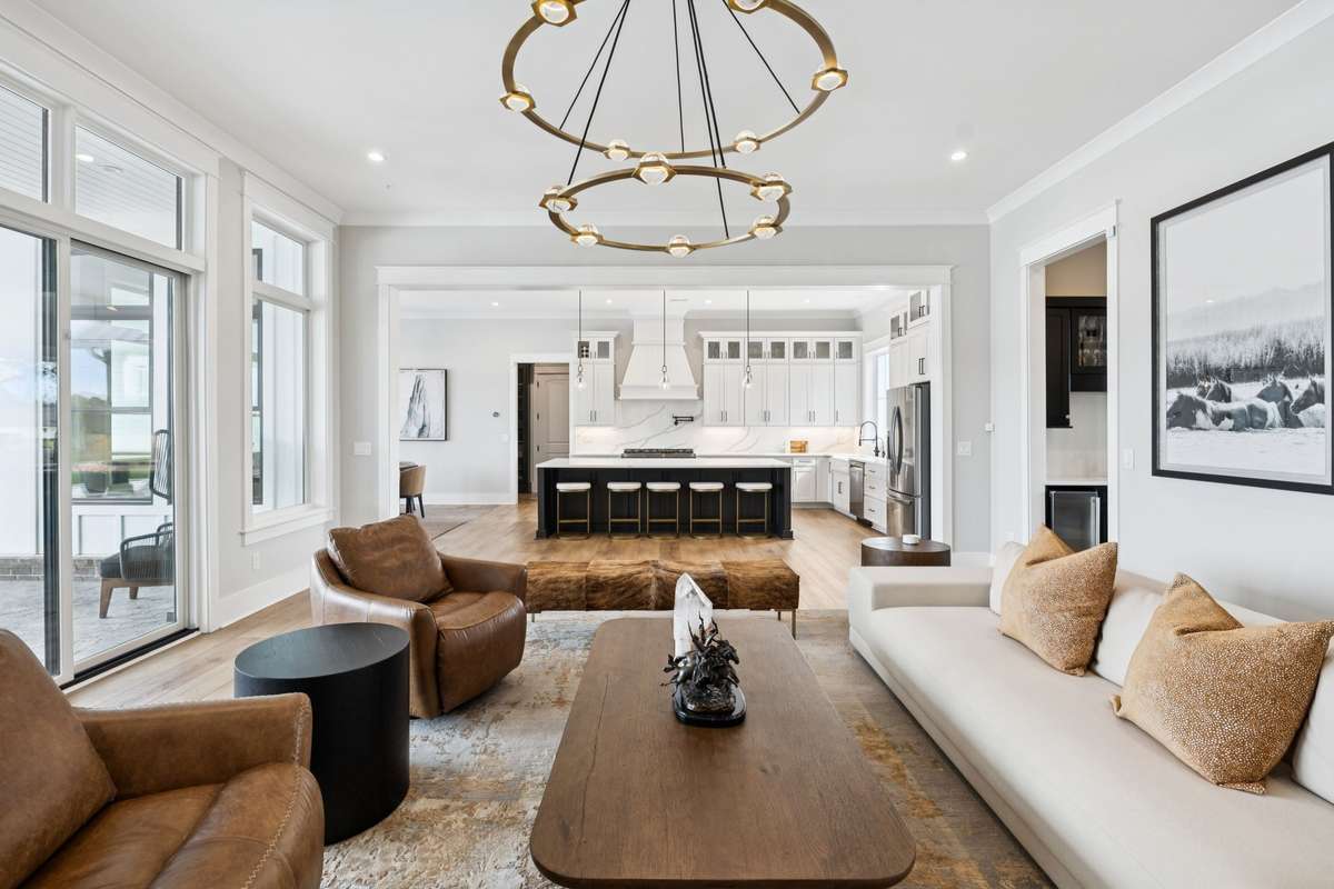 Bright, open living space flows effortlessly into the chef’s kitchen. Large windows and sliding doors overlook the pool and patio, while the oversized island with seating creates a natural gathering spot for entertaining and everyday living.