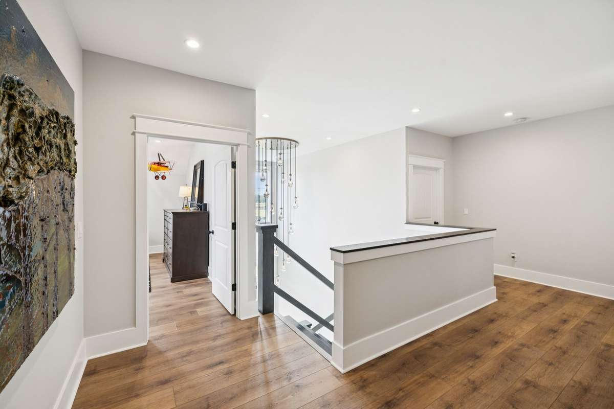 Open upper landing offers additional flex space ideal for a reading nook, study area, or secondary living space. Overlooks the stairwell below and provides easy access to upstairs bedrooms and baths.