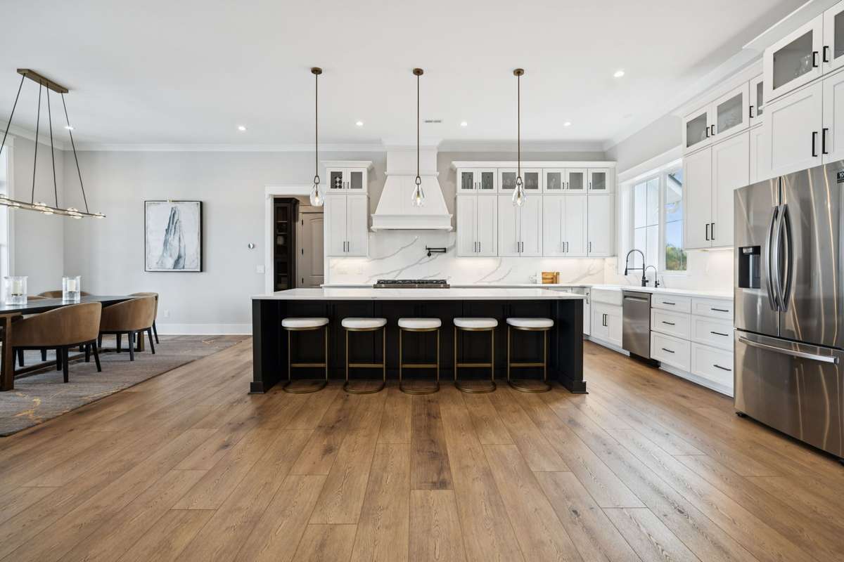 Spacious kitchen with oversized island seating, custom cabinetry, and professional-grade appliances. Open to the dining area, the layout is designed for effortless entertaining while maintaining clean lines and a bright, timeless aesthetic.