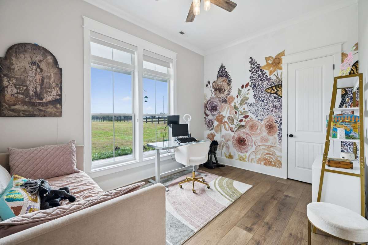 Bright secondary bedroom with large windows overlooking scenic countryside views. Generous layout offers flexibility for guests, family, or a private office while enjoying abundant natural light.